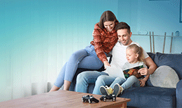 Family sitting on couch reading children's book