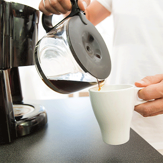 A closeup of a man pouring coffee into a mug